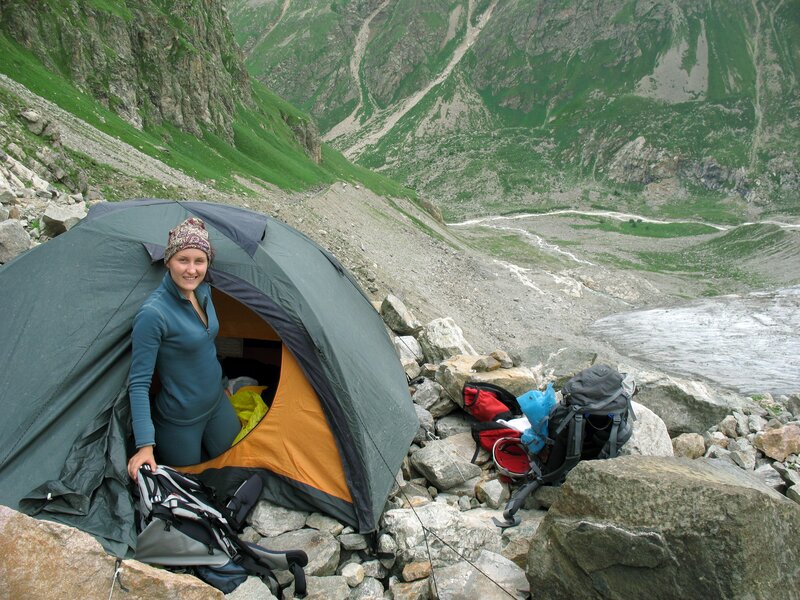 Woman camping in mountain valley
