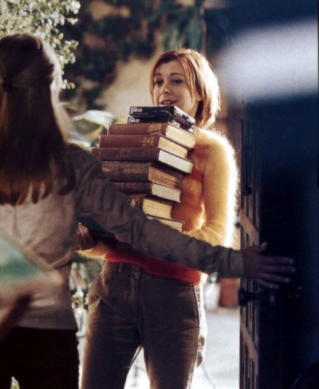 woman carrying books at door