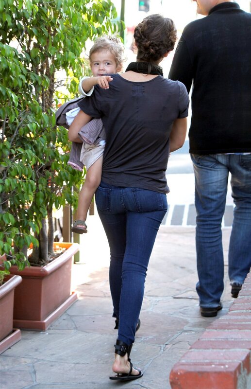 woman carrying child on sidewalk