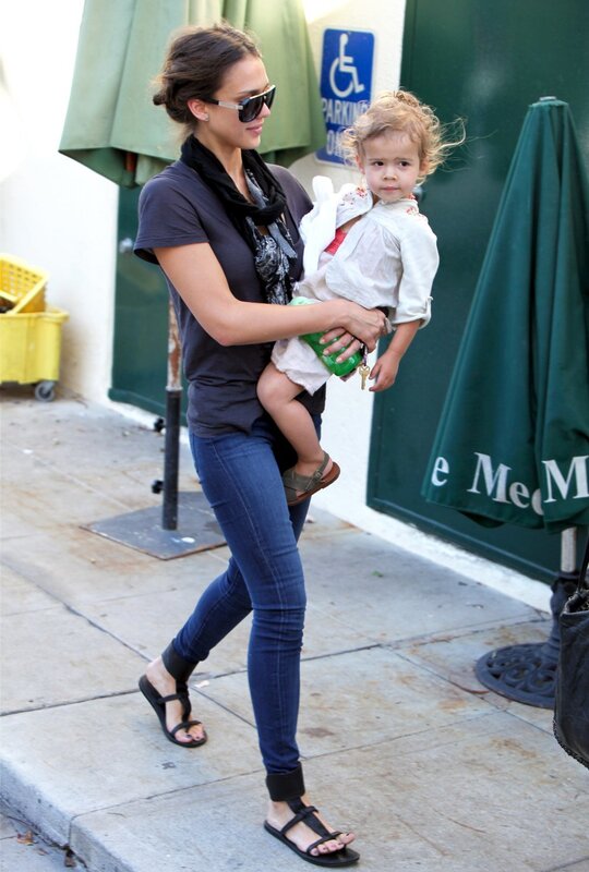 woman carrying child on sidewalk