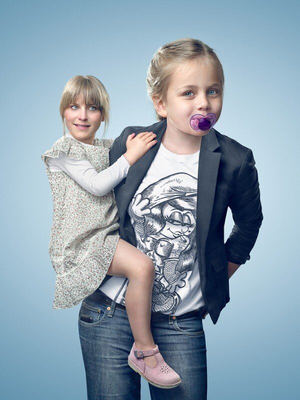 woman carrying child with pacifier