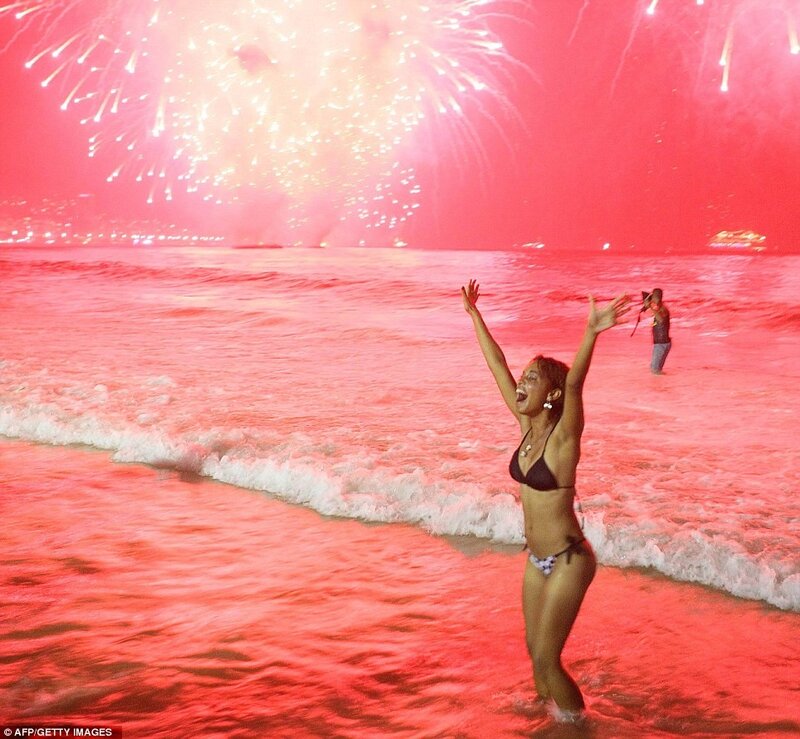 Woman celebrating at beach with fireworks