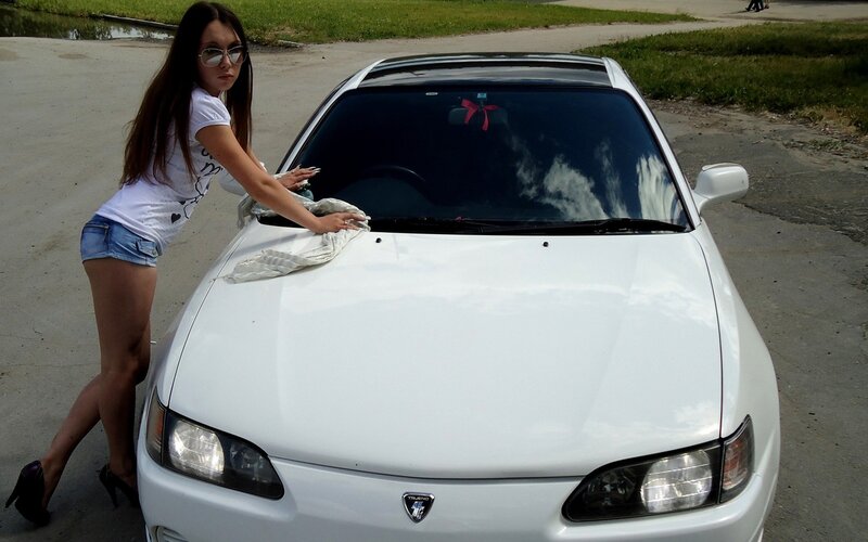 woman cleaning a white car