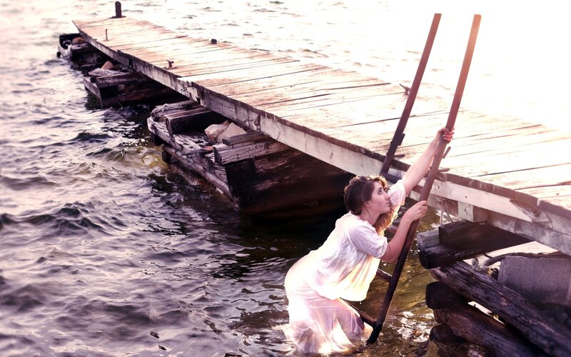 woman climbing ladder from water