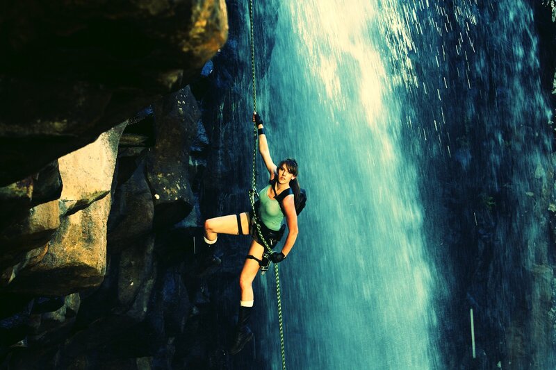 Woman climbing near waterfall
