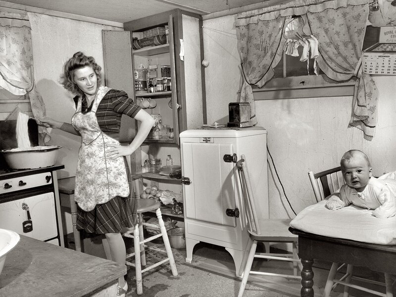 Woman cooking with baby in kitchen