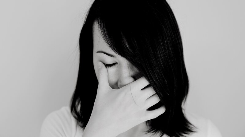 woman covering face in distress