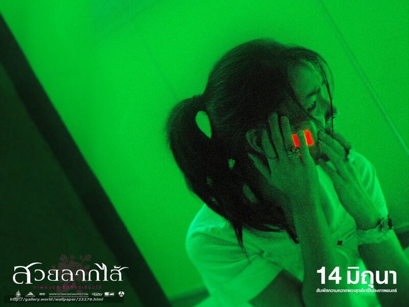 woman covering face in green light