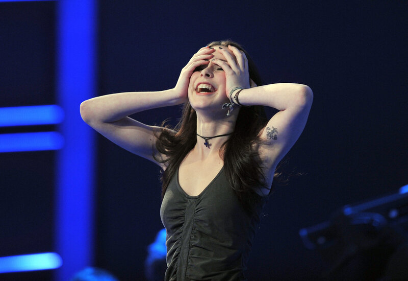 woman covering face on stage