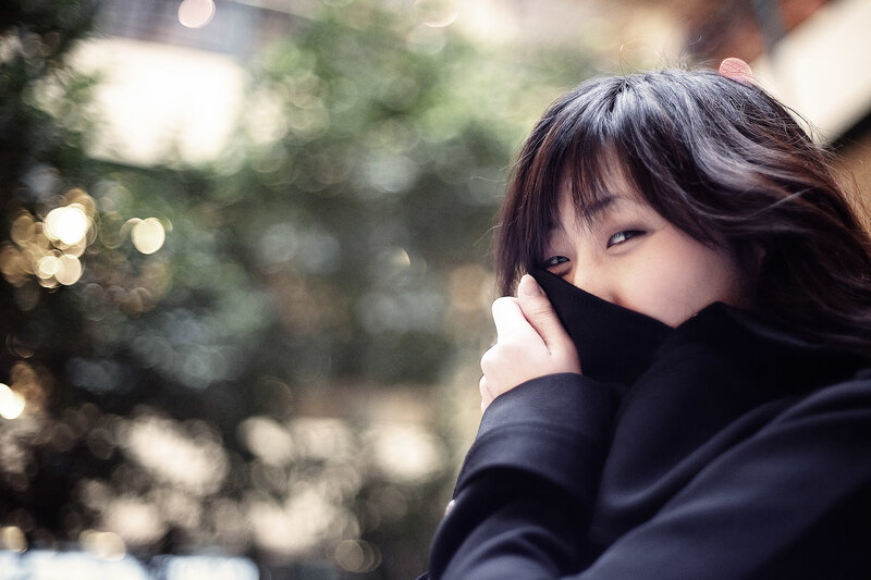 woman covering face with coat