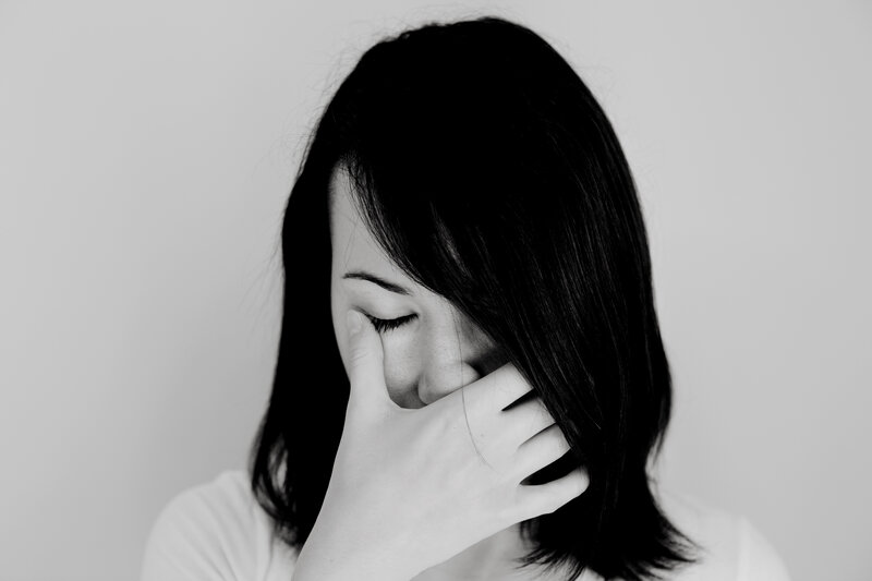 woman covering face with hand