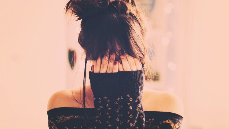 woman covering face with hands