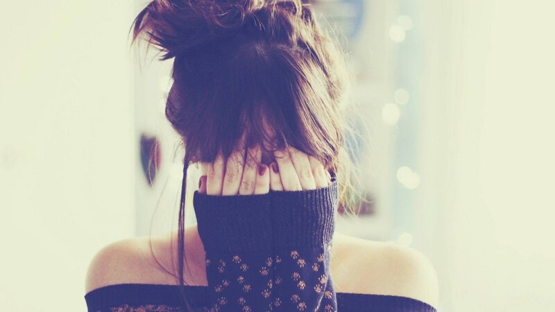 woman covering face with hands