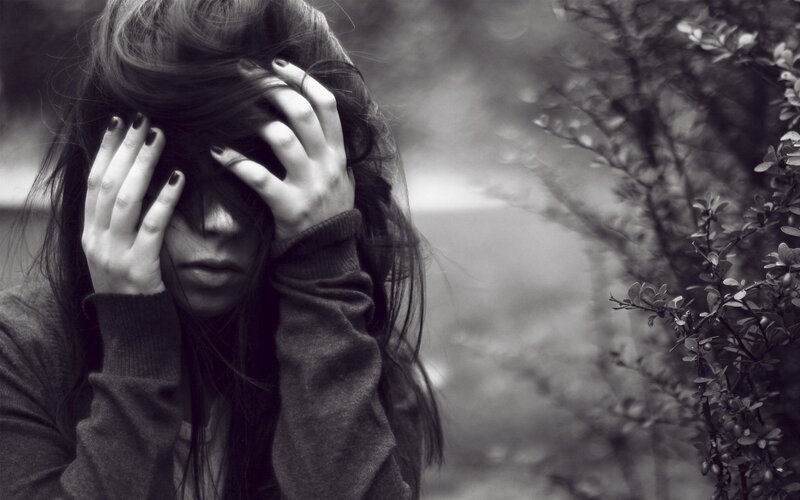 woman covering face with hands