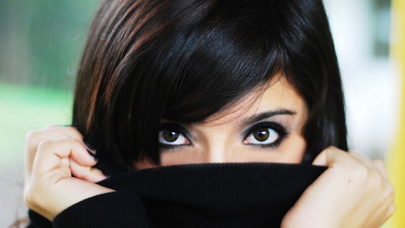 woman covering face with sweater