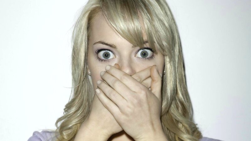 woman covering mouth in shock