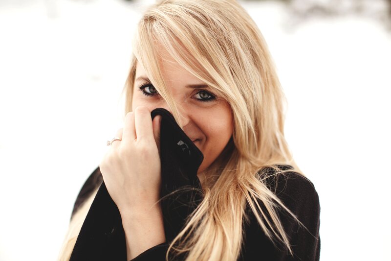 woman covering mouth with coat