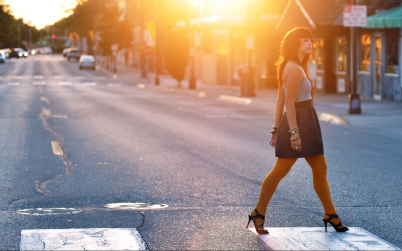 woman crossing street at sunset