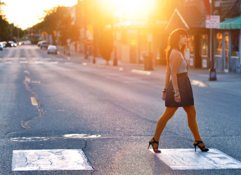woman crossing street at sunset