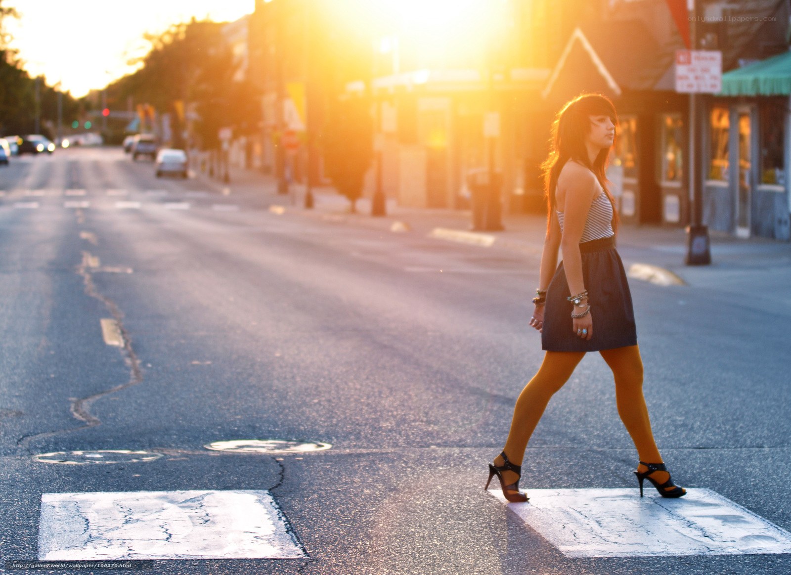 woman crossing street at sunset