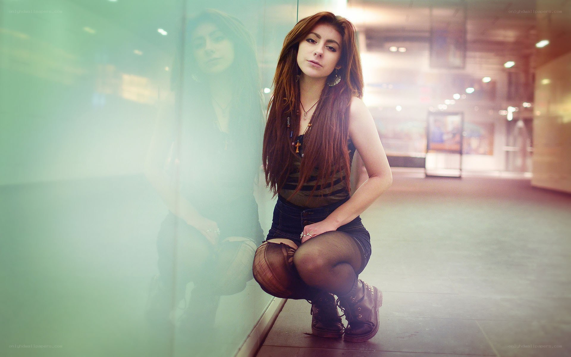 woman crouching by glass wall