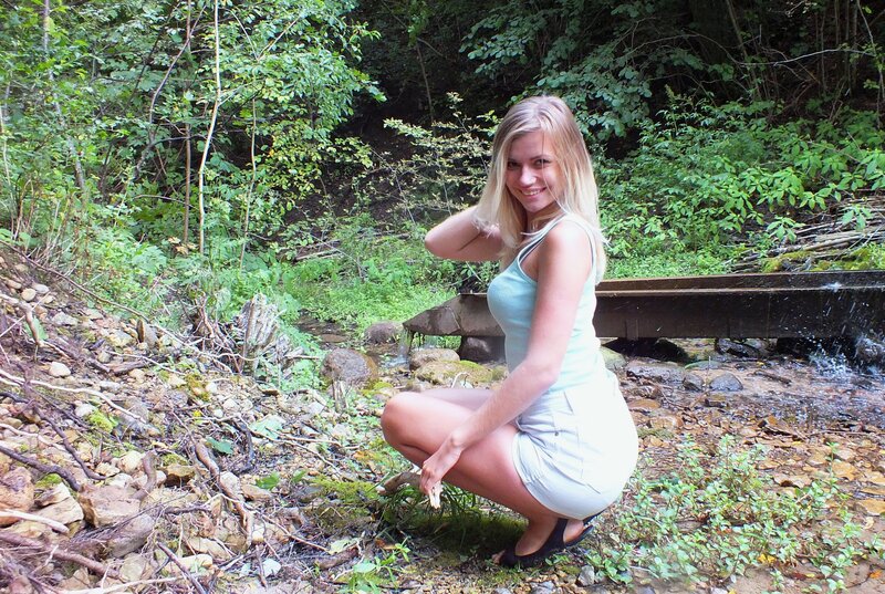 Woman Crouching by Stream