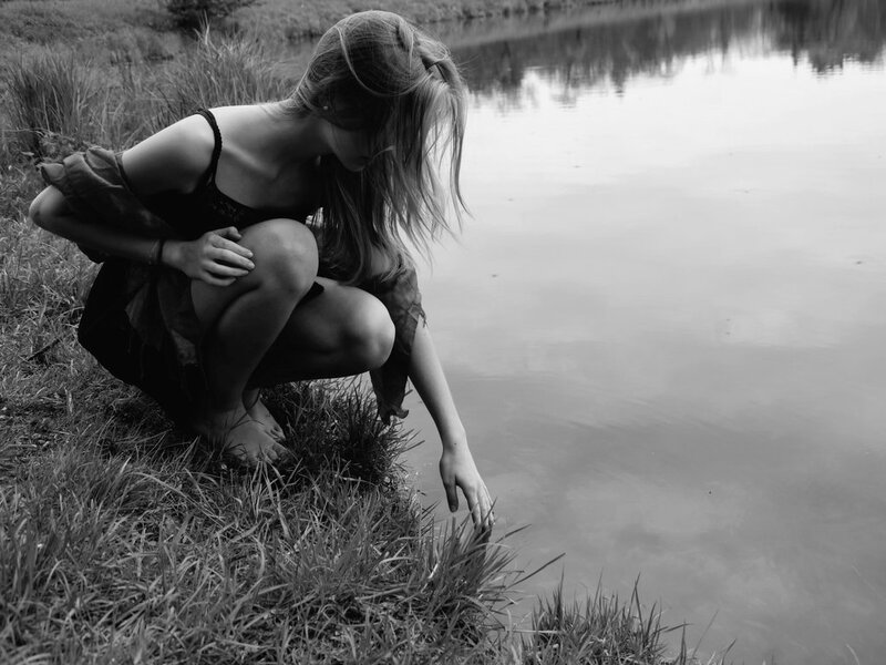 Woman Crouching by Water — Black