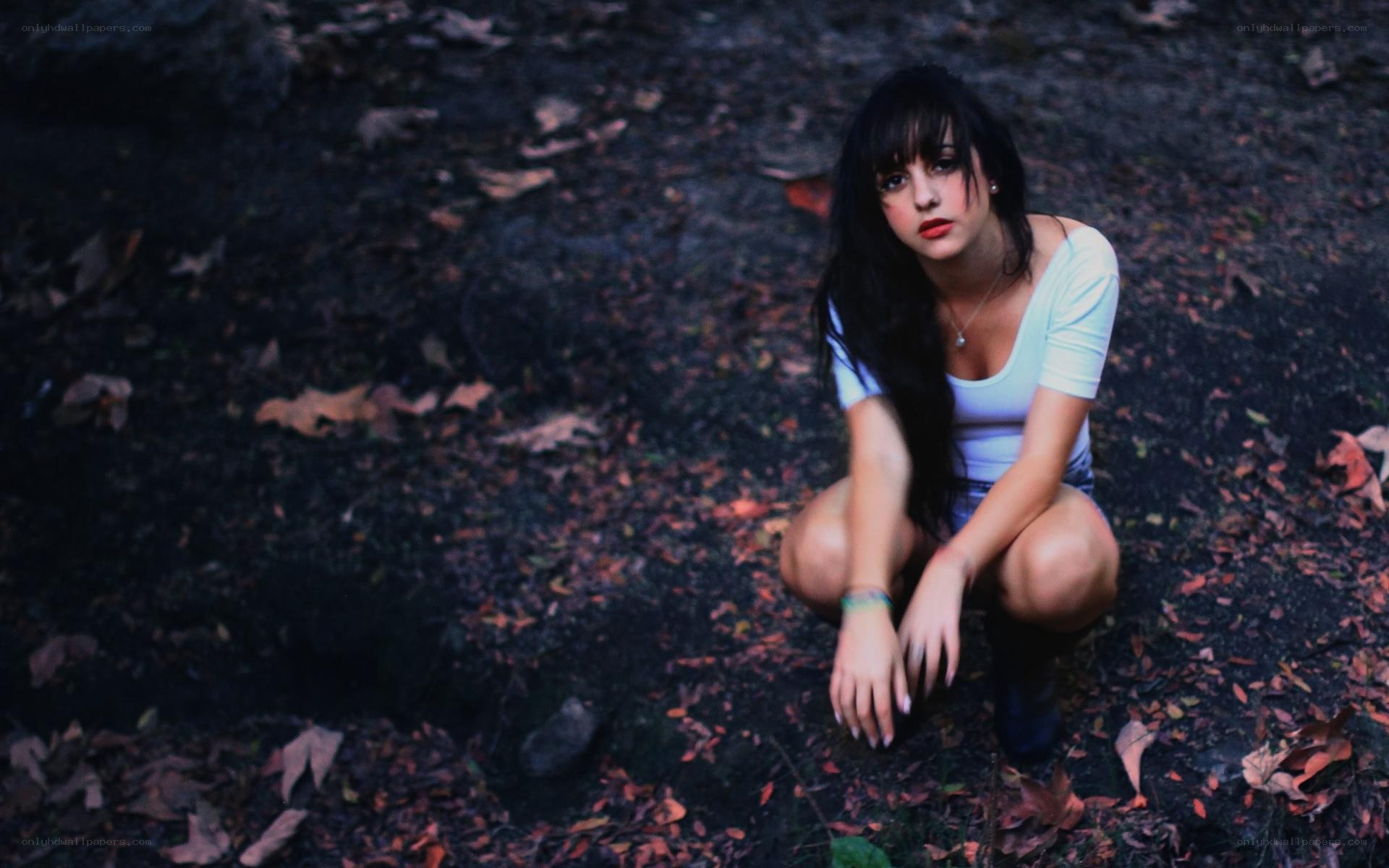 woman crouching in forest