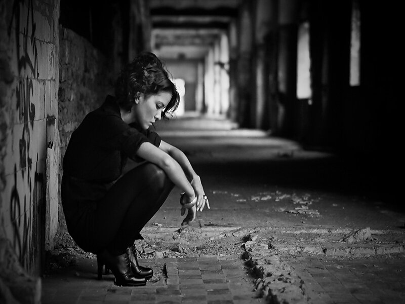 Woman Crouching in Hallway
