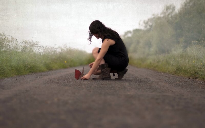 Woman crouching on a road