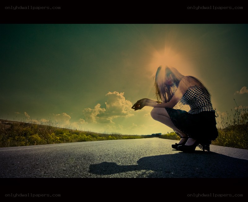 woman crouching on road at sunset