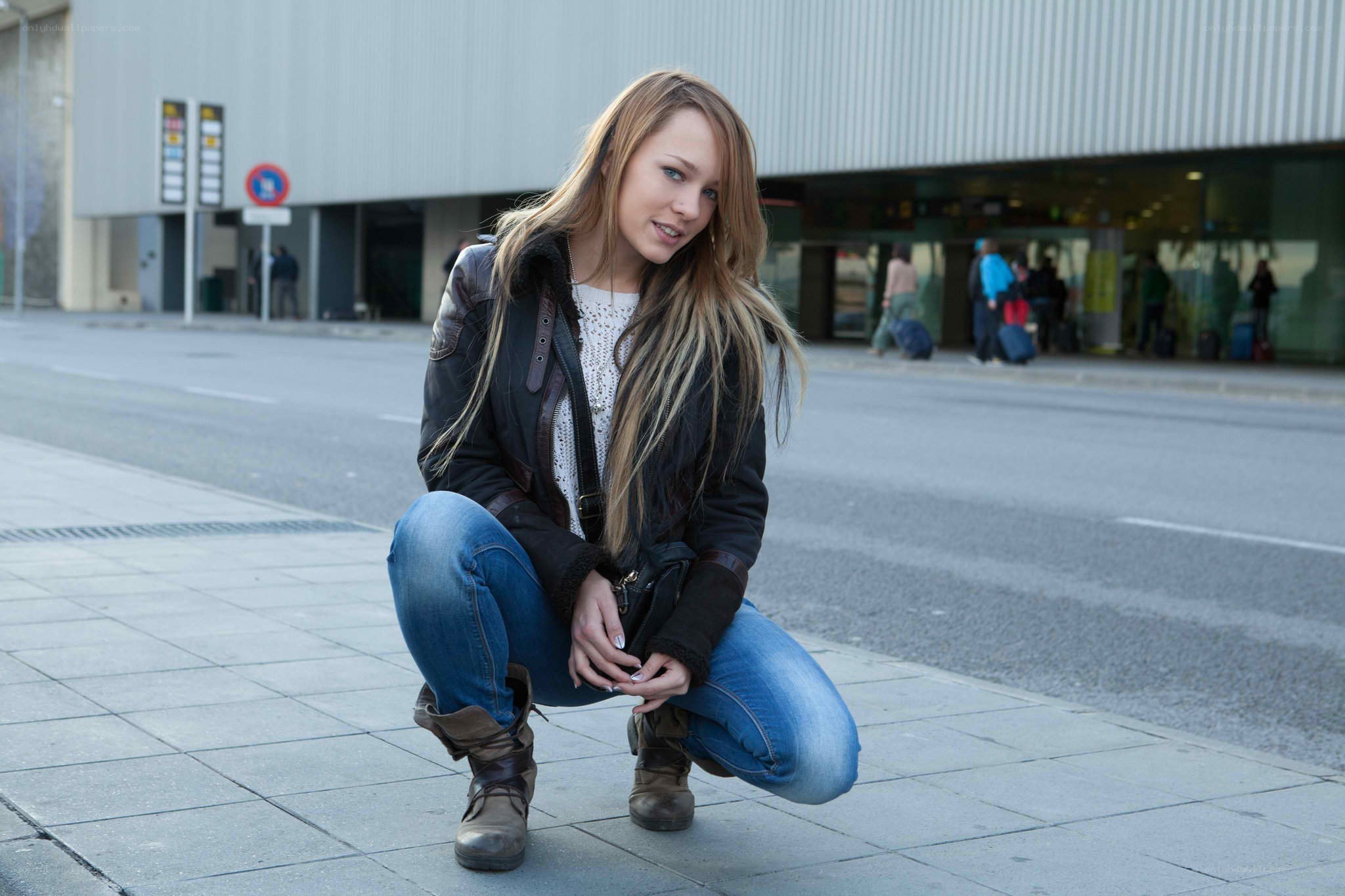 woman crouching on sidewalk
