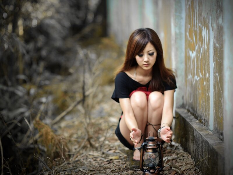 Woman Crouching with Lantern — Brown