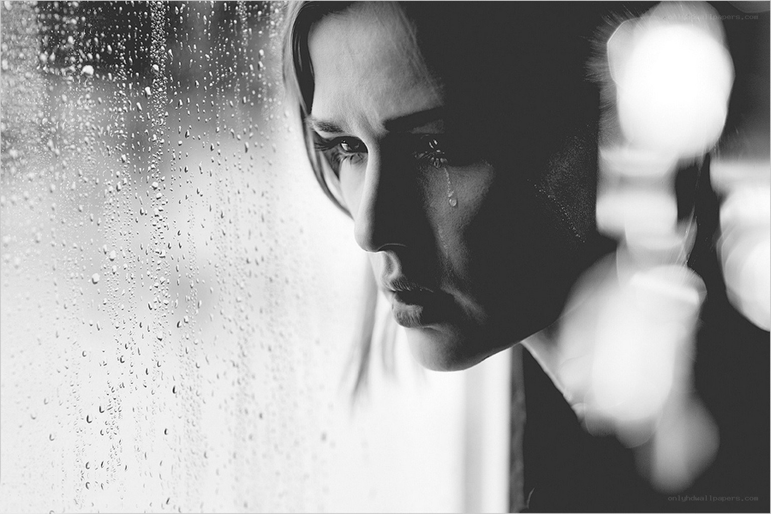 woman crying at rainy window