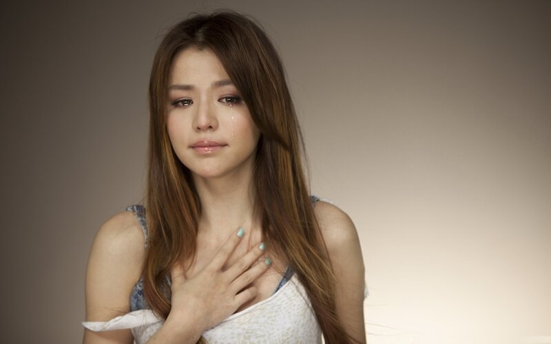 woman crying with hand on chest
