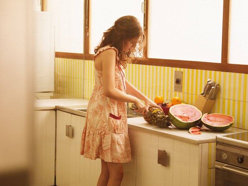 woman cutting fruit in kitchen