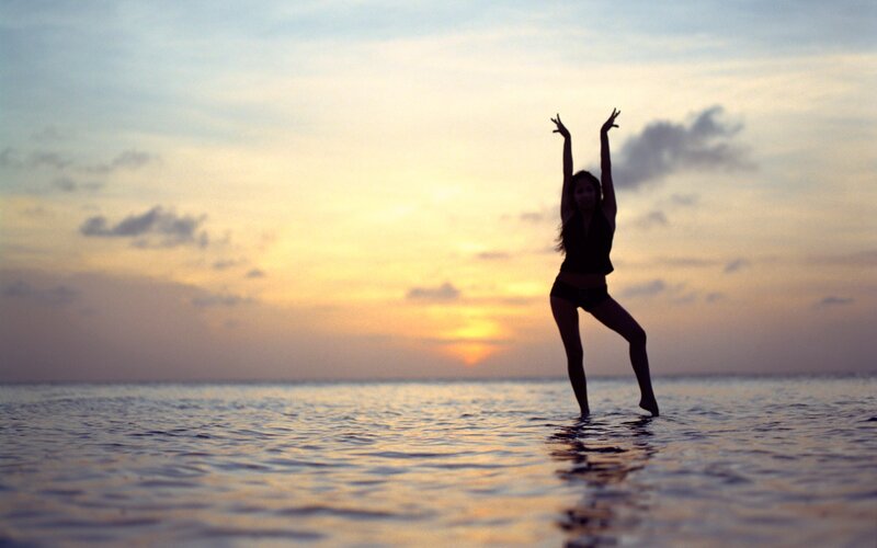 woman dancing at sunset in water