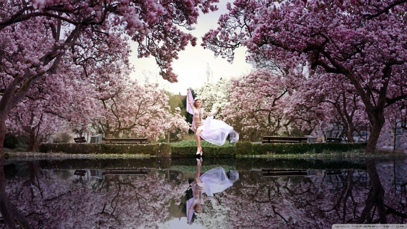 Woman dancing in cherry blossom garden