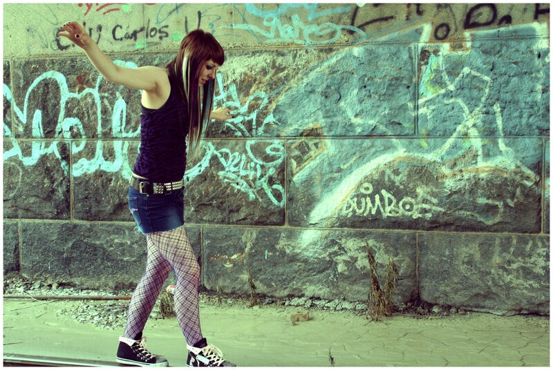 woman dancing in front of graffiti wall