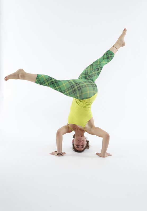 woman doing handstand in plaid leggings