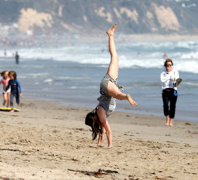 Woman doing handstand on beach