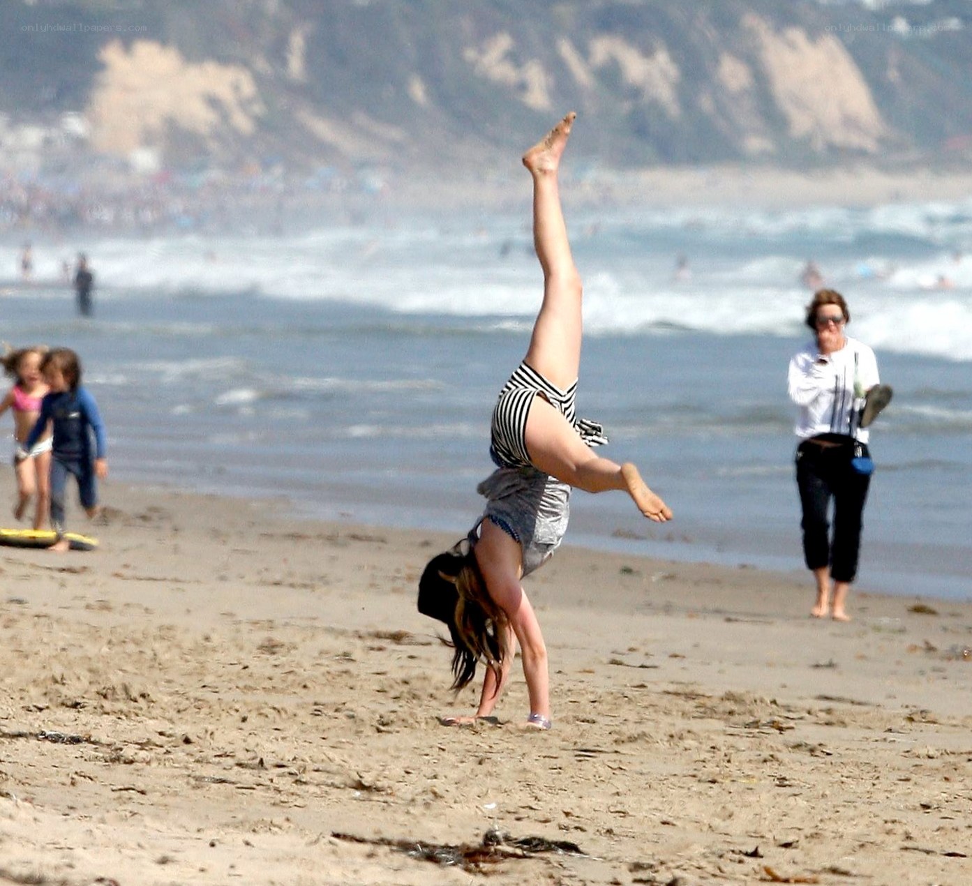 Woman doing handstand on beach