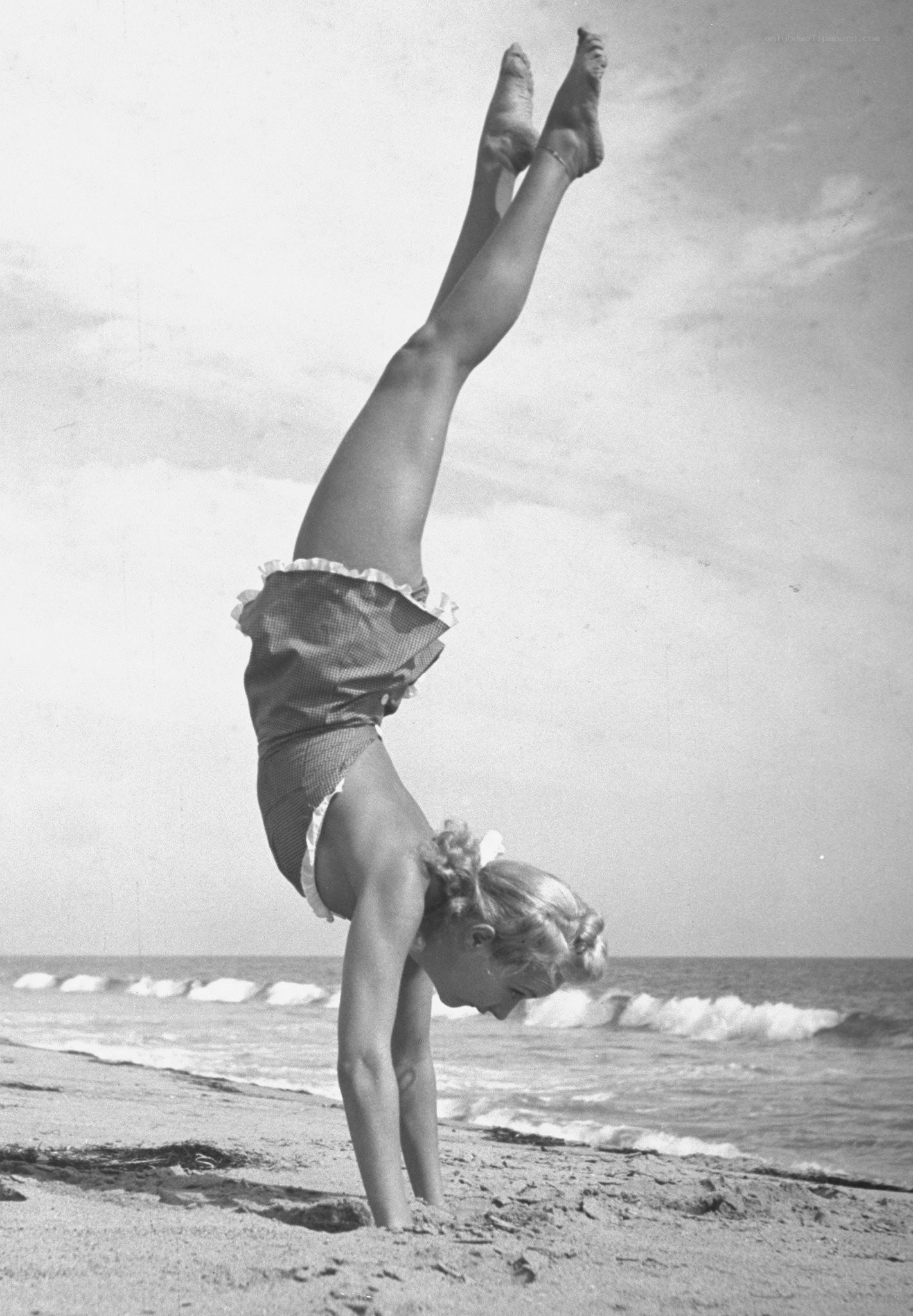 Woman doing handstand on beach