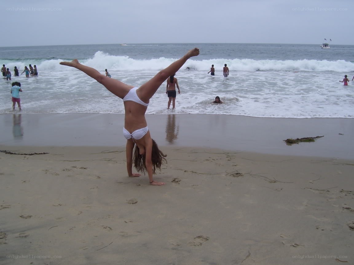 woman doing handstand on beach