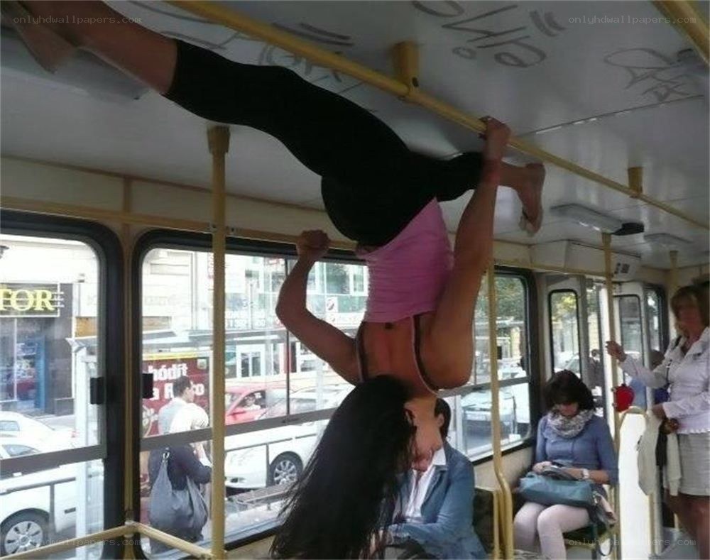 Woman doing handstand on bus