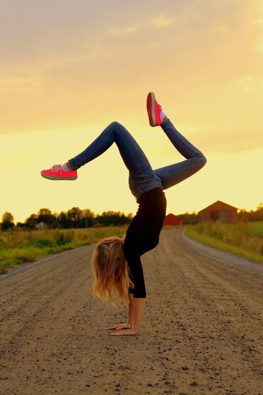 Woman doing handstand on road