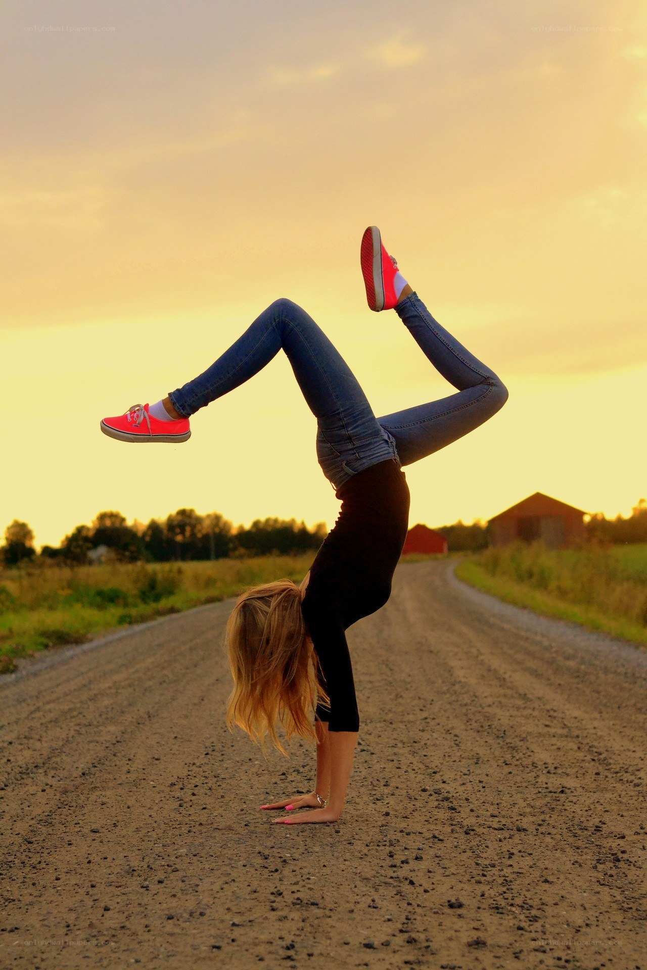 Woman doing handstand on road