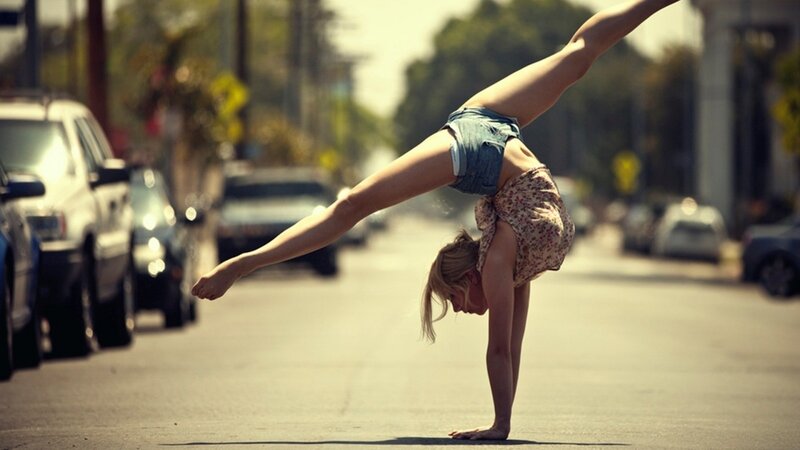 woman doing handstand on street