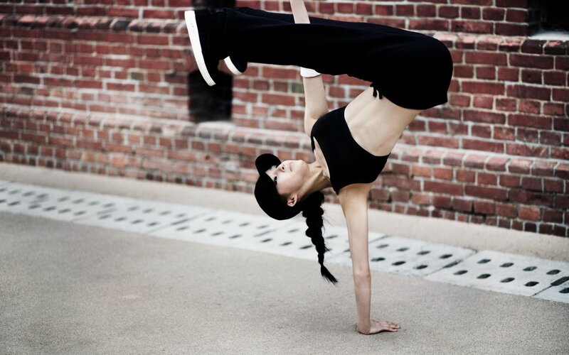 woman doing handstand on street