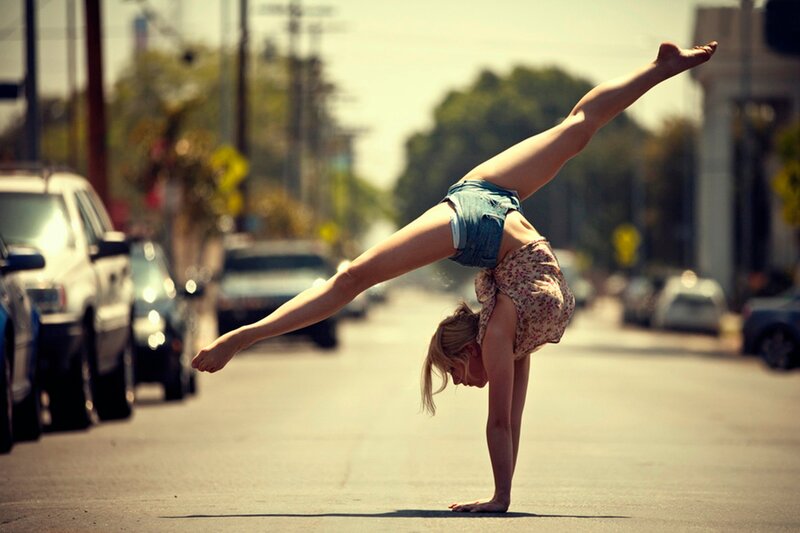 woman doing handstand on street